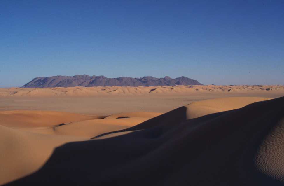 Pendant la traversée de l’erg d’Izane (l’adrar Chiriet au fond), le 24 février 2004