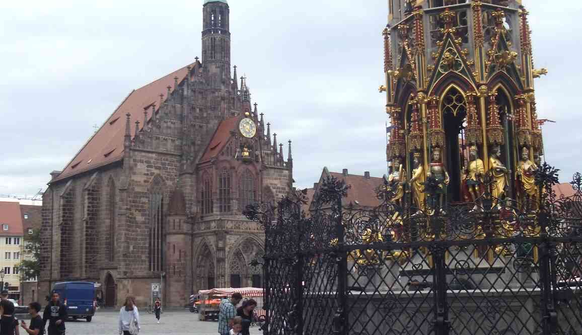 Nuremberg, place du Marché et Frauenkirche (église catholique Notre-Dame). À droite la Belle fontaine (Schöner Brunnen), œuvre de Heinrich Beheim de 1385 à 1396. Il s’agit d’une copie installée en 1912 et qui a résisté aux bombardements. 17 août 2019